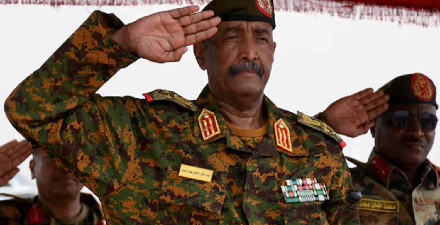 Sudan's General Abdel Fattah al-Burhan salutes as he listens to the national anthem after landing in the military airport of Port Sudan.