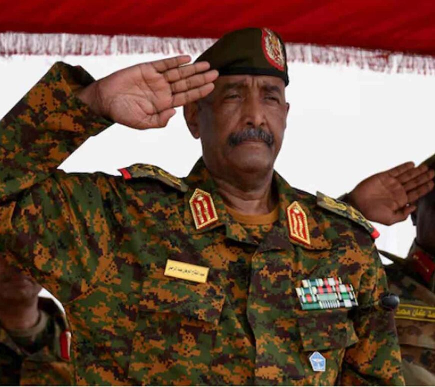 Sudan's General Abdel Fattah al-Burhan salutes as he listens to the national anthem after landing in the military airport of Port Sudan.