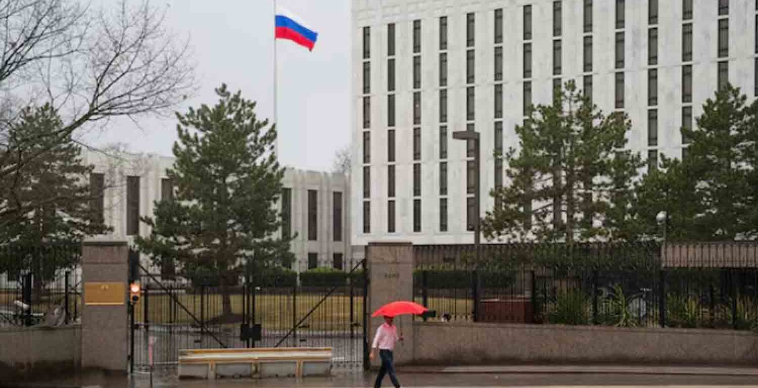 A pedestrian walks with an umbrella outside the Embassy of the Russian Federation, near the Glover Park neighborhood of Washington, U.S.