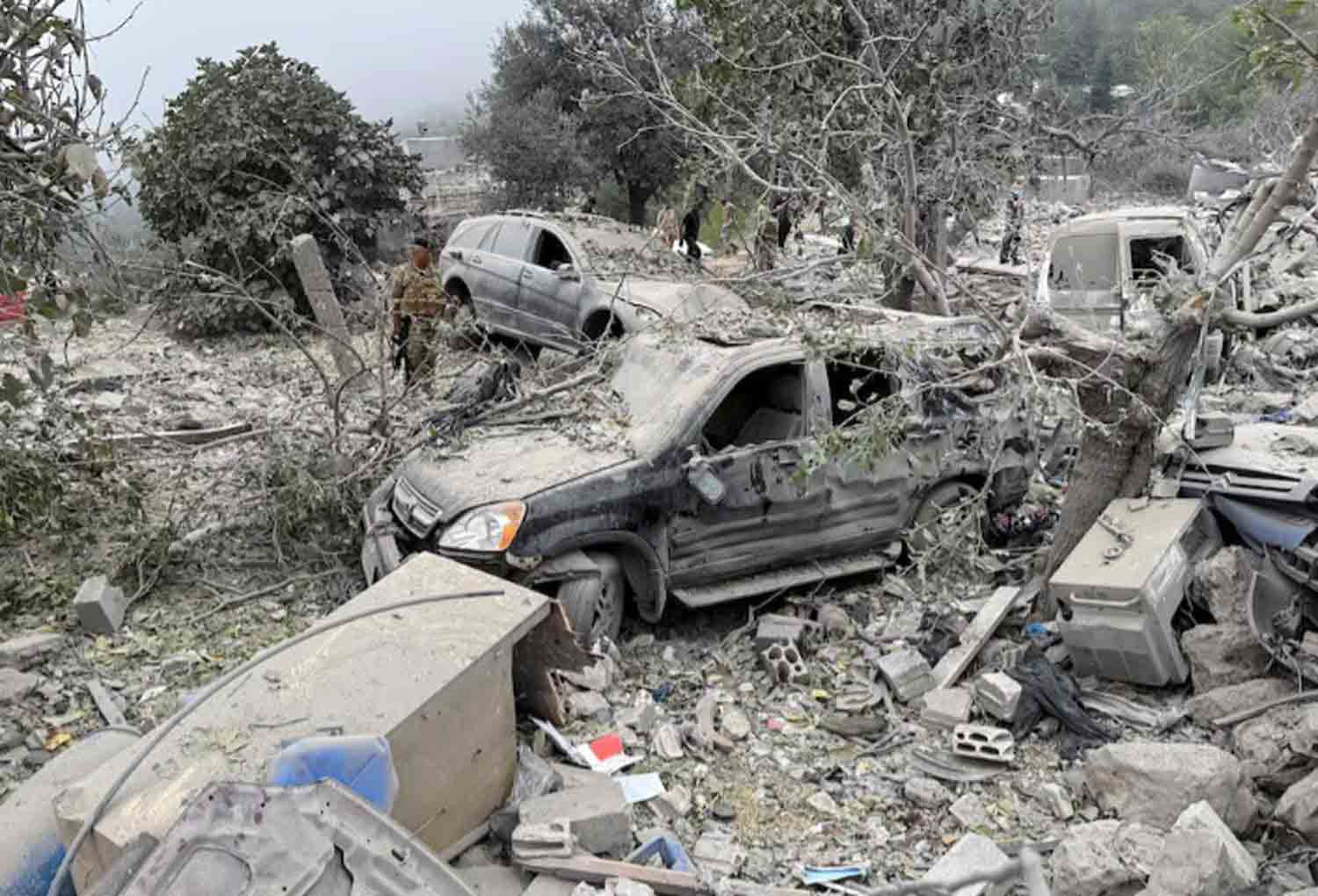 site-damaged-by-an-Israeli-air-strike-in-Lebanon Lebanese army soldier stands near destroyed vehicles at a site damaged by an Israeli air strike in the Christian-majority region of Aitou in north Lebanon.