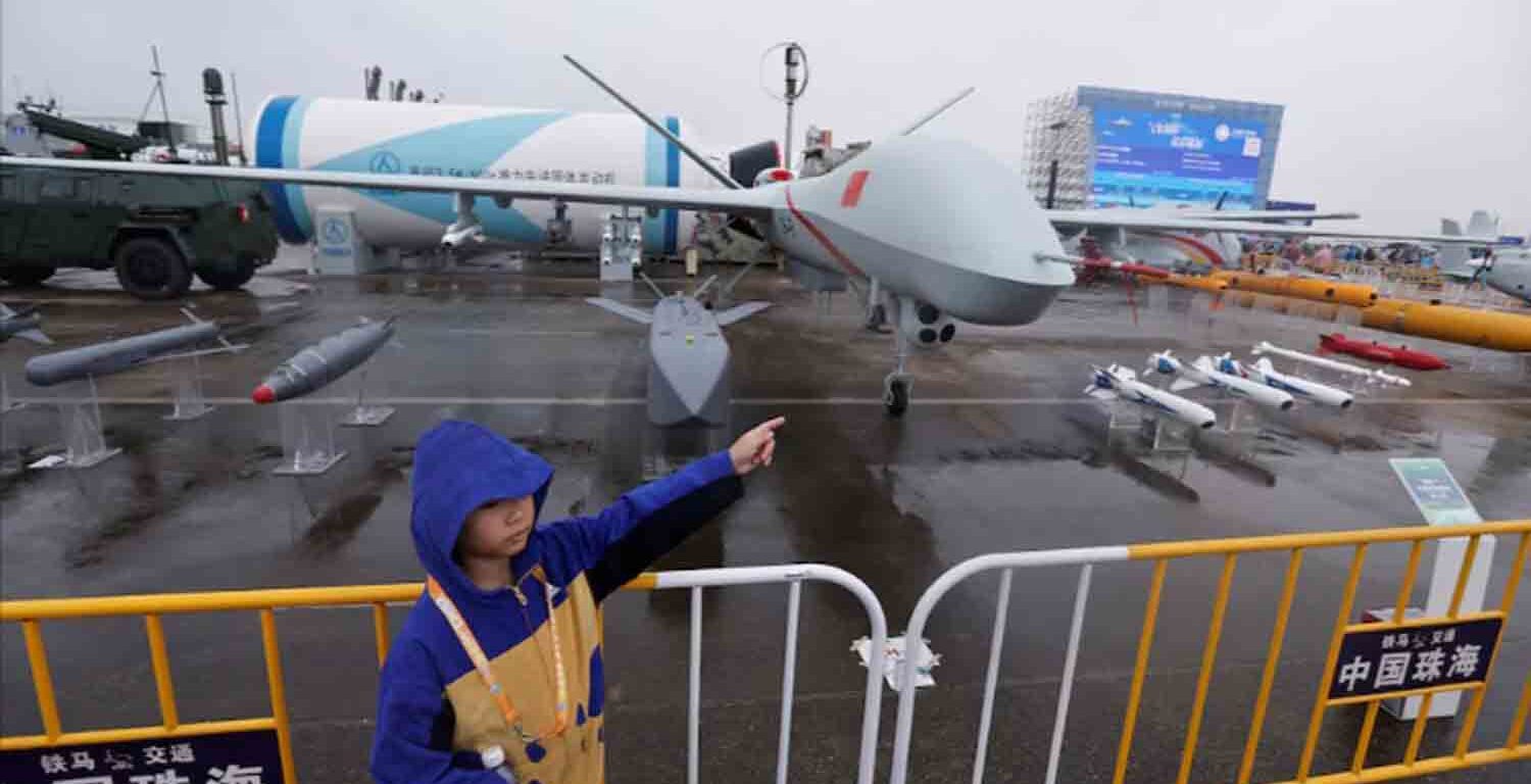 A visitor stands next to a CH-9 combat drone displayed at the China International Aviation and Aerospace Exhibition, or Airshow China, in Zhuhai, Guangdong province, China.