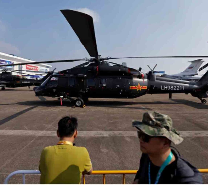 People stand near a Z-20 helicopter displayed at the China International Aviation and Aerospace Exhibition, or Airshow China, in Zhuhai, Guangdong province, China.