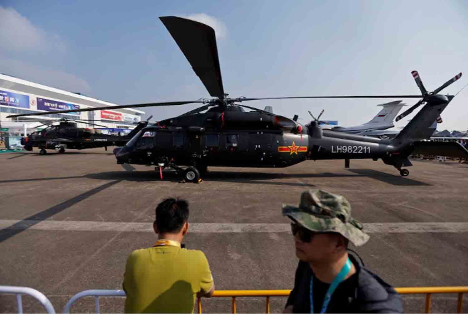 People stand near a Z-20 helicopter displayed at the China International Aviation and Aerospace Exhibition, or Airshow China, in Zhuhai, Guangdong province, China.