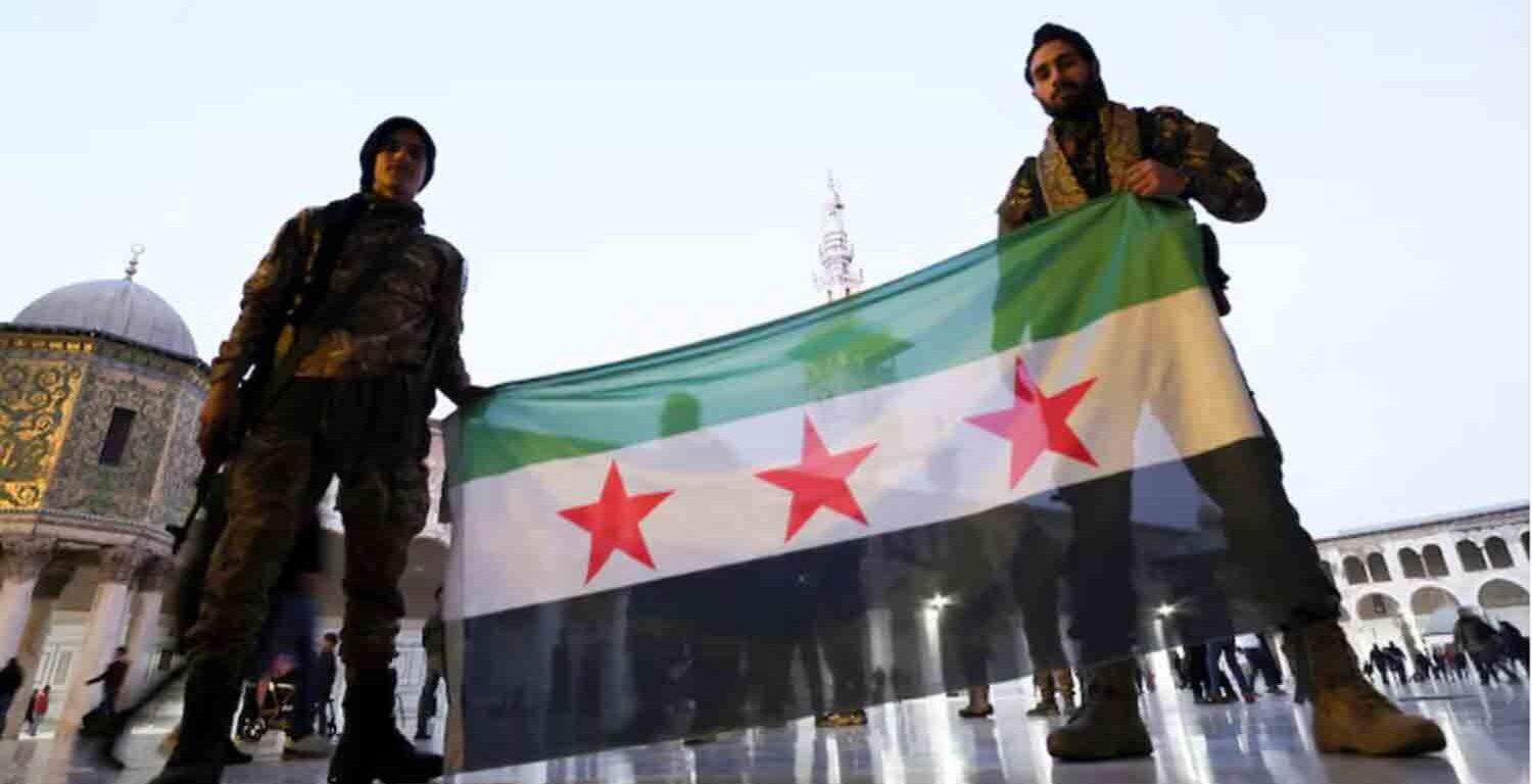 Rebel fighters pose as they hold a Syrian opposition flag inside the Umayyad Mosque, after rebels seized the capital and ousted Syria's Bashar al-Assad, in Damascus, Syria.