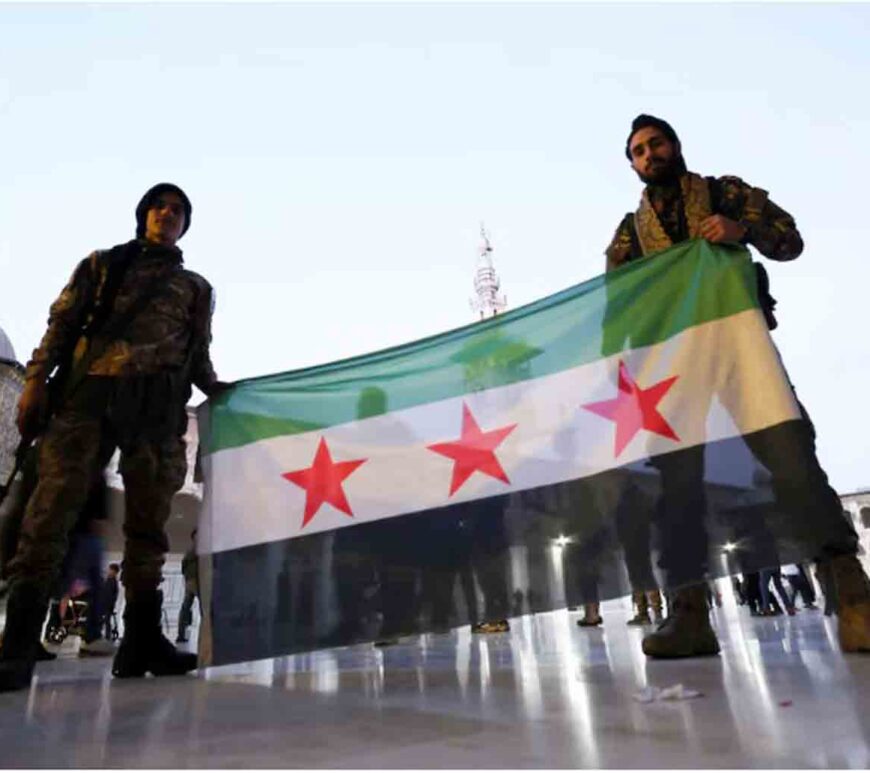 Rebel fighters pose as they hold a Syrian opposition flag inside the Umayyad Mosque, after rebels seized the capital and ousted Syria's Bashar al-Assad, in Damascus, Syria.