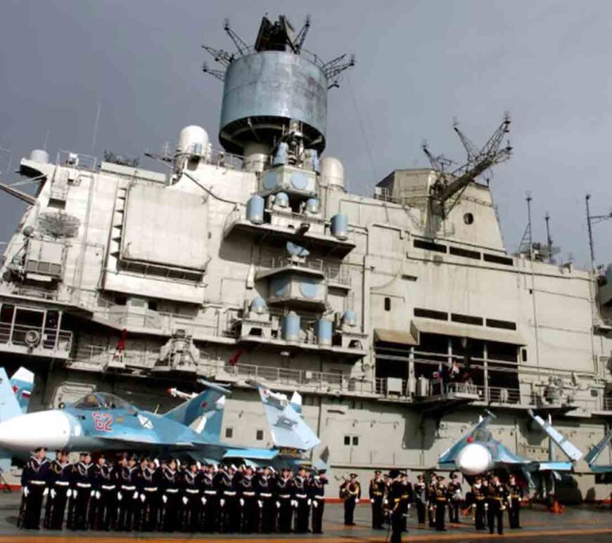 Naval personnel stand in front of the Russian aircraft carrier Kuznetsov in the Syrian city of Tartous on the Mediterranean sea