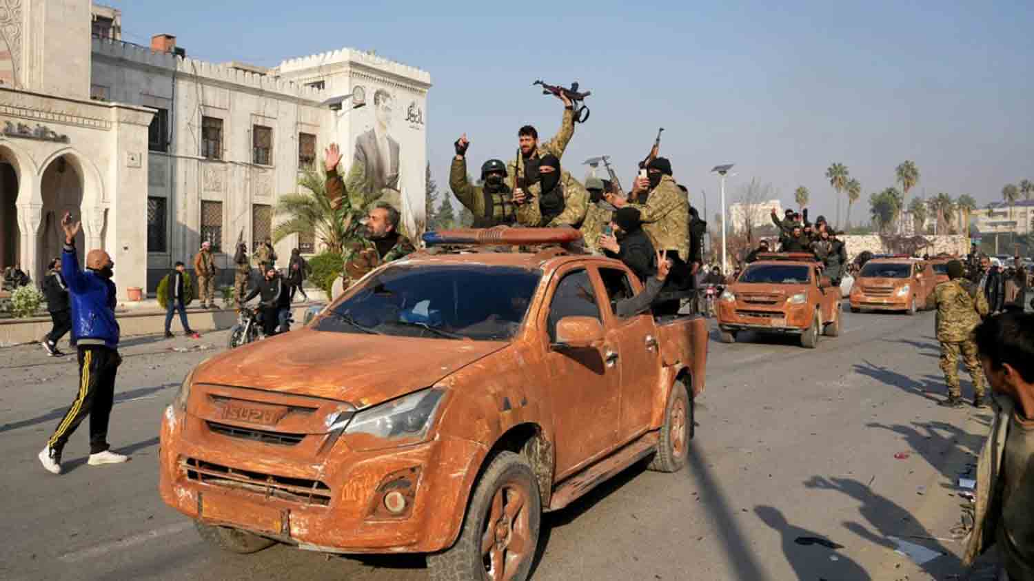 Syrian anti-government fighters celebrate as they pour into the captured central-west city of Hama.