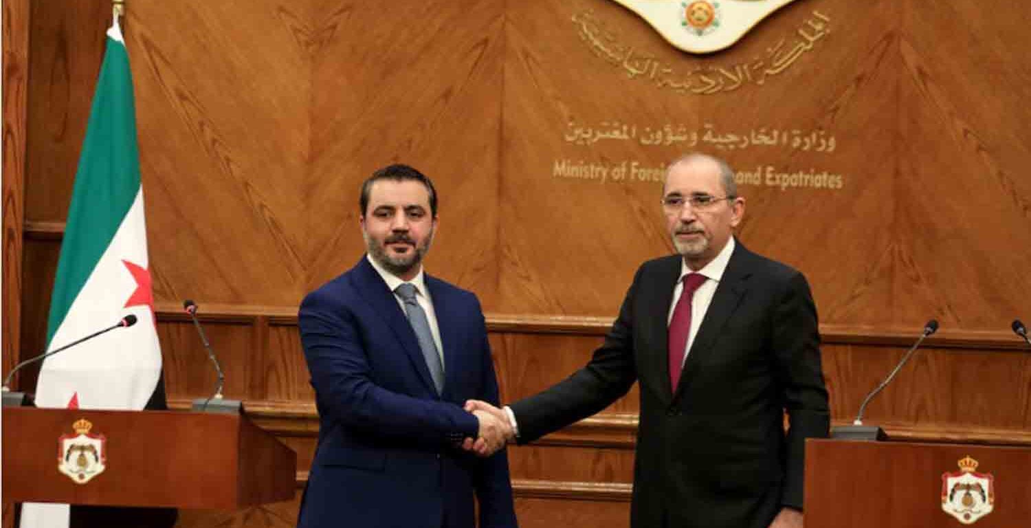 Syrian Foreign Minister Asaad Hassan al-Shibani and Jordanian Foreign Minister Ayman Safadi shake hands during a press conference as they meet in Amman, Jordan.