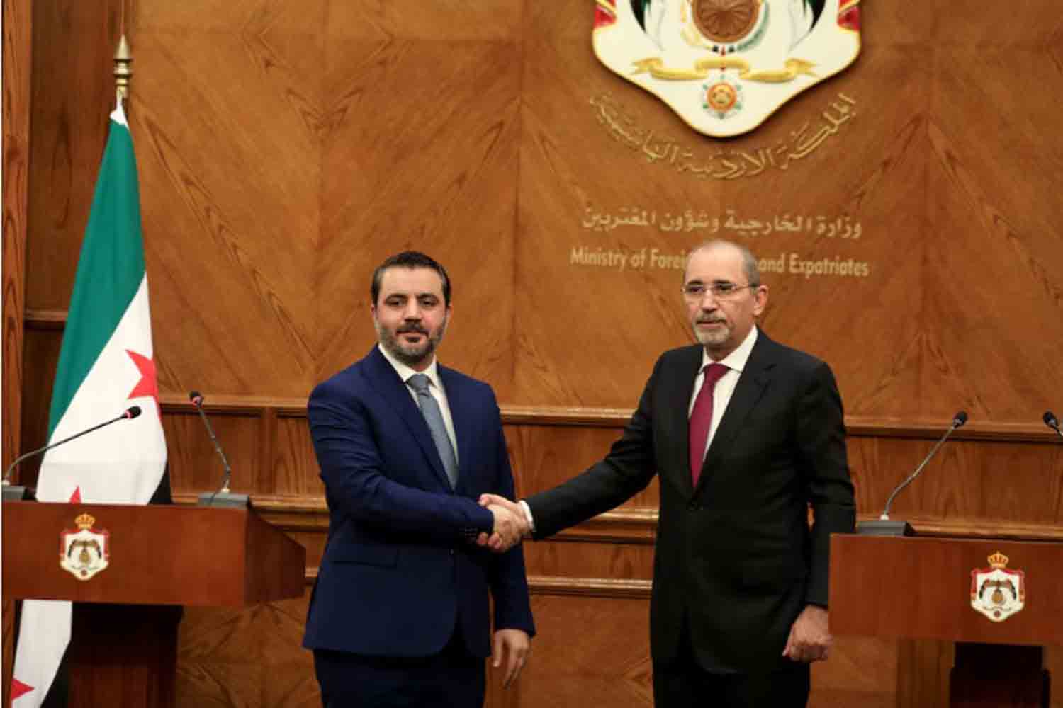 Syrian Foreign Minister Asaad Hassan al-Shibani and Jordanian Foreign Minister Ayman Safadi shake hands during a press conference as they meet in Amman, Jordan.