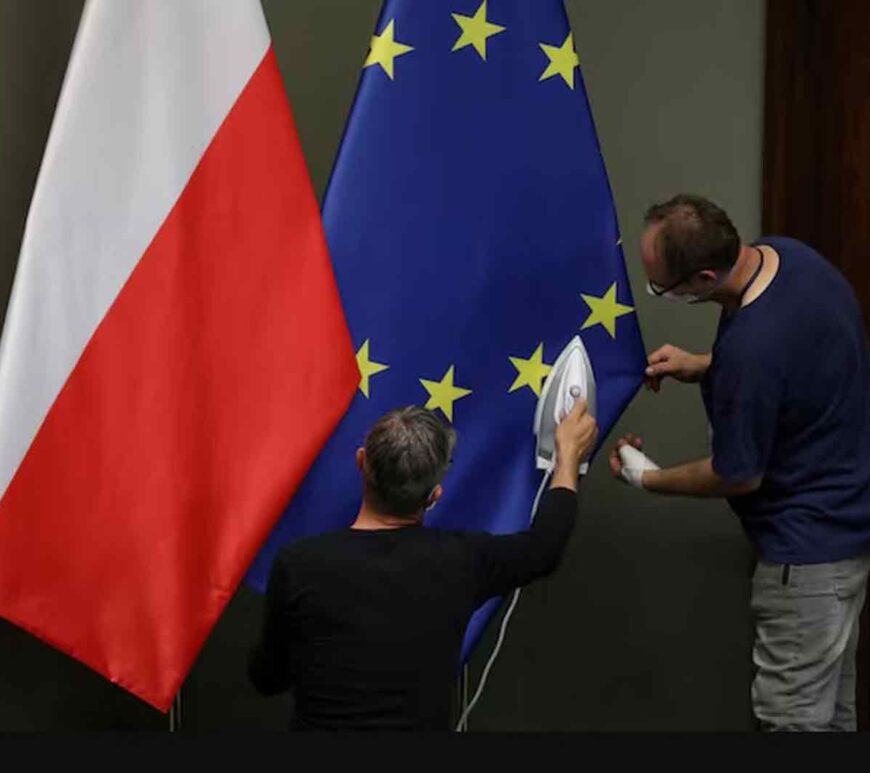 Workers iron flags of European Union and Poland in Warsaw, Poland.