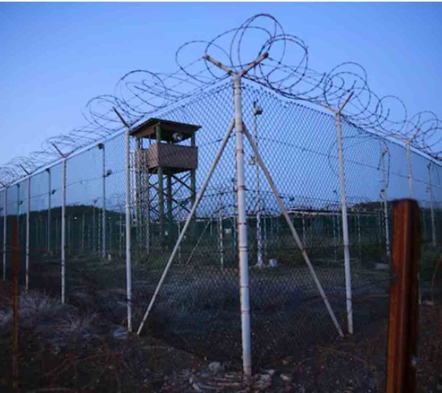 Chain link fence and concertina wire surrounds a deserted guard tower within Joint Task Force Guantanamo's Camp Delta at the U.S. Naval Base in Guantanamo Bay, Cuba.