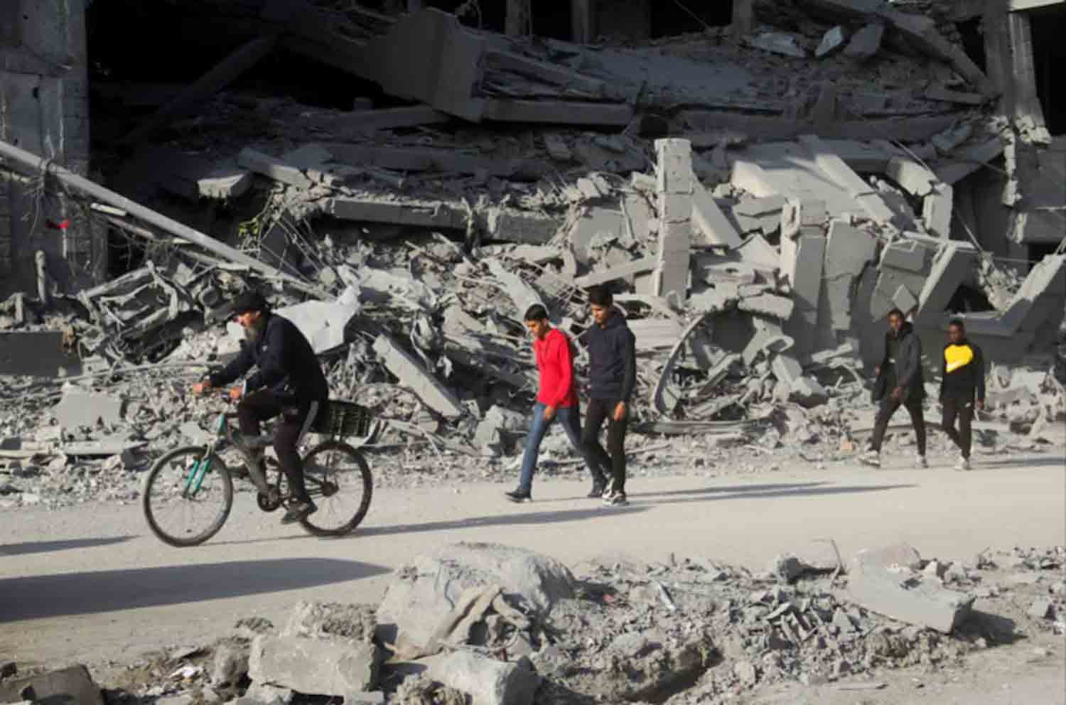 Palestinians walk among the rubble of houses destroyed in previous Israeli strikes, amid ceasefire negotiations with Israel, in Gaza City.