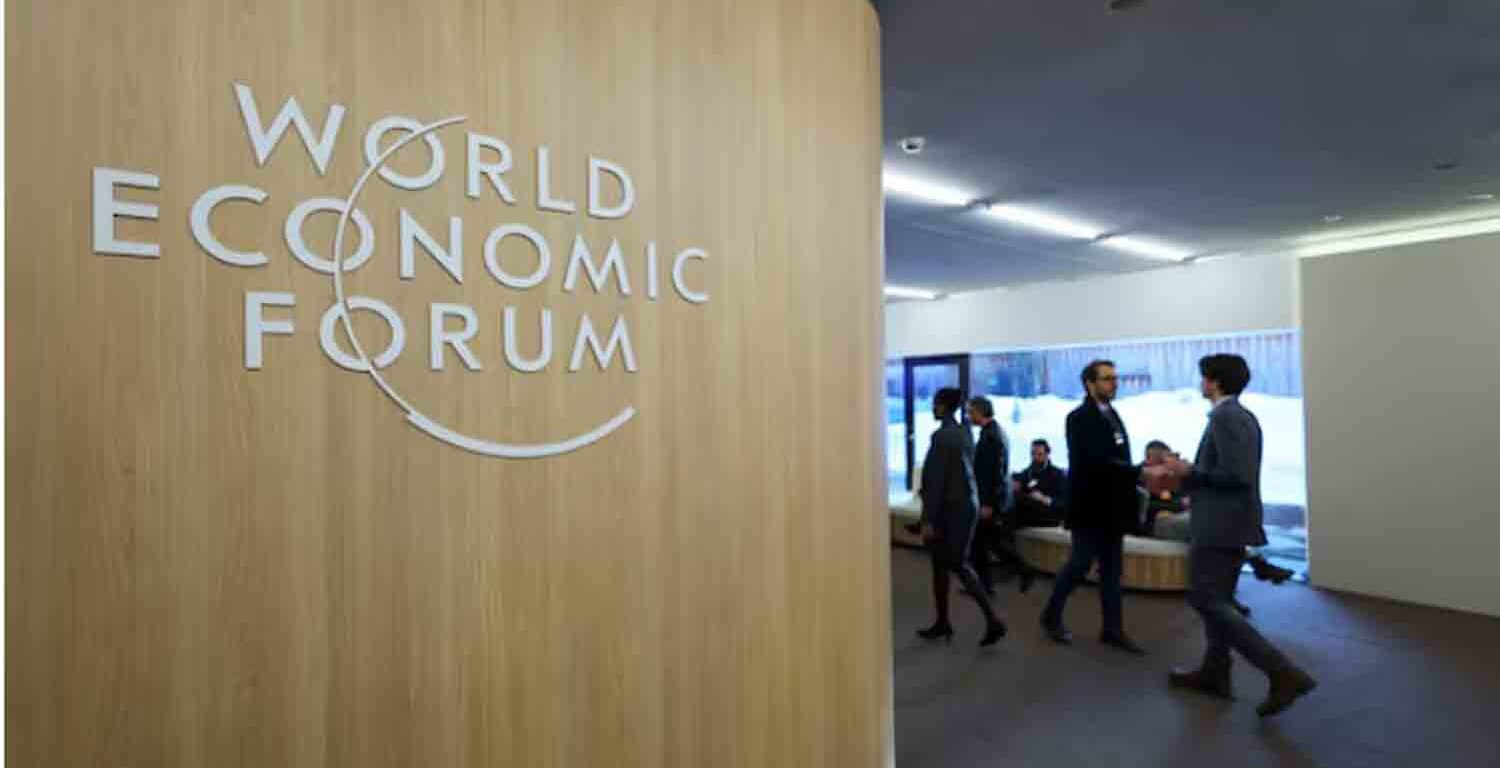 People walk next to the logo of World Economic Forum (WEF) on the first day of the annual meeting in Davos, Switzerland,.