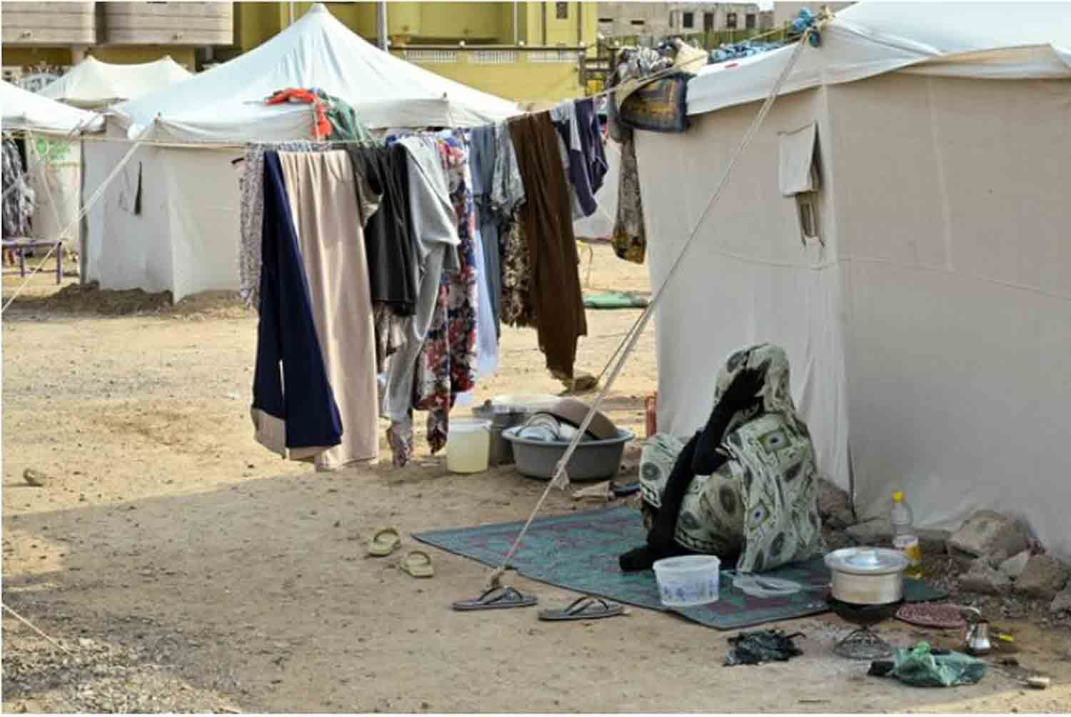 displaced-woman-sits-outside-at-a-school-turned-into-a-shelter,-in-Port-Sudan A displaced woman sits outside at a school turned into a shelter, in Port Sudan, Sudan.