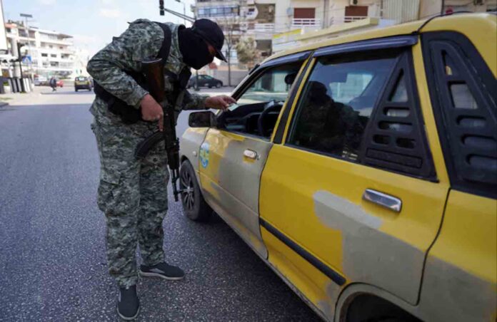 A member of the Syrian security forces checks an ID of a person, after hundreds were killed in some of the deadliest violence in 13 years of civil war, pitting loyalists of deposed President Bashar al-Assad against the country's new Islamist rulers in Latakia, Syria.