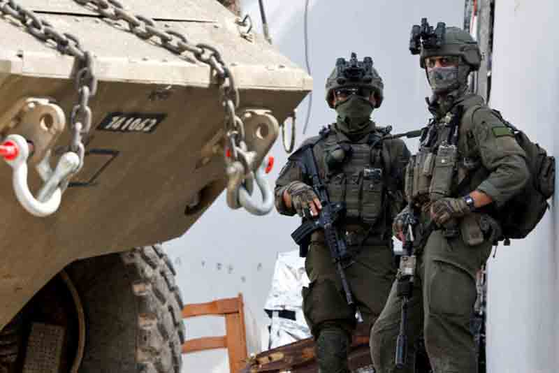 Israeli-soldiers Israeli soldiers stand next to a military vehicle during an Israeli raid in Jenin, in the Israeli-occupied West Bank.