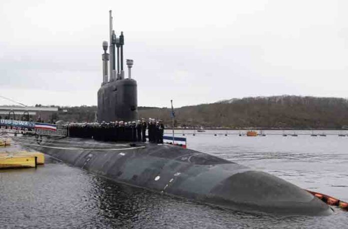 U.S. sailors assigned to the Virginia-class fast attack submarine USS Iowa (SSN 797) man the rails during a commissioning ceremony at Naval Submarine Base New London in Groton, Conn.