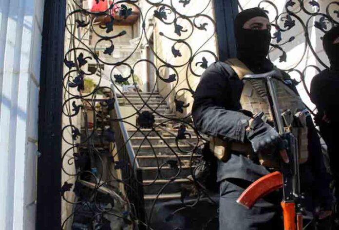 member of Syrian security forces stands guard at a damaged site, after Israel carried out an air strike on the Syrian capital Damascus.