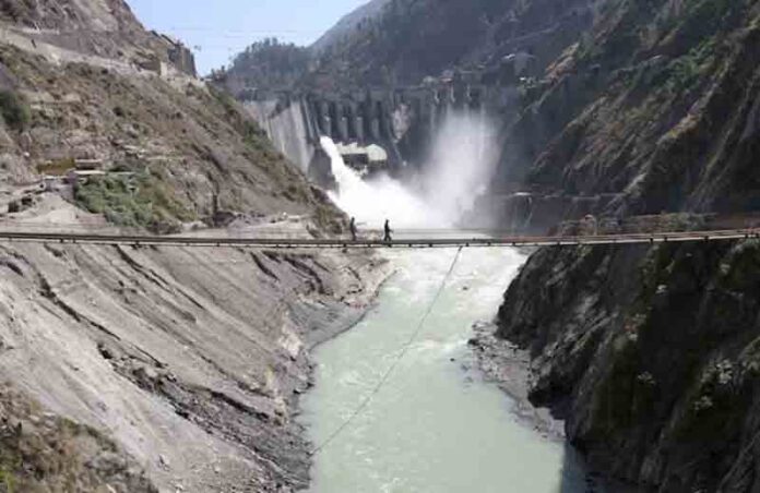 Labourers walk on a bridge near the 450-megawatt hydropower project located at Baglihar Dam on the Chenab river which flows from Indian Kashmir into Pakistan, at Chanderkote, about 145 km (90 miles) north of Jammu.