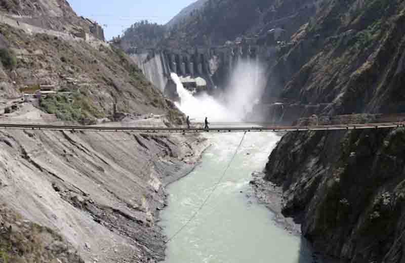 Labourers walk on a bridge near the 450-megawatt hydropower project located at Baglihar Dam on the Chenab river which flows from Indian Kashmir into Pakistan, at Chanderkote, about 145 km (90 miles) north of Jammu.