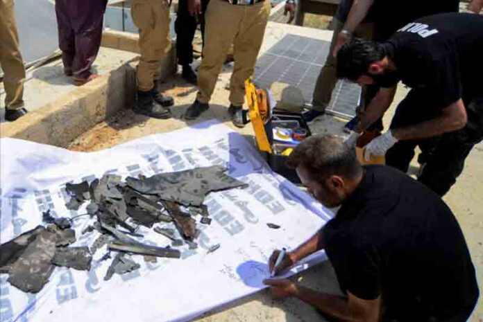 indian-drone-debris-near-karachi A member of the Crime Scene Unit (CSU), inspects the fregments, of what they say is a drone, after it was brought down on the outskirts of Karachi, Pakistan.
