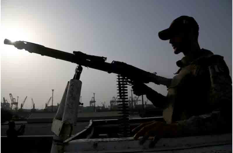 A paramilitary trooper mans a gun atop a vehicle as he keeps guard during a media tour of the Karachi Port, Pakistan.