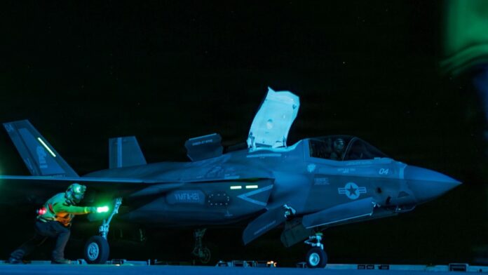 USS Tripoli conducts night flight operations while sailing in the Arabian Sea.
