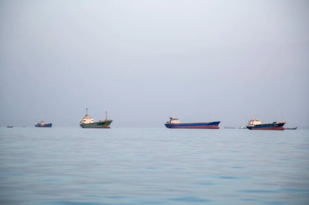 Ships are anchored near the shoreline, in Bandar Abbas, Iran. Bandar Abbas is a port city and the capital of Hormozgan Province, along the Persian Gulf and Strait of Hormuz.