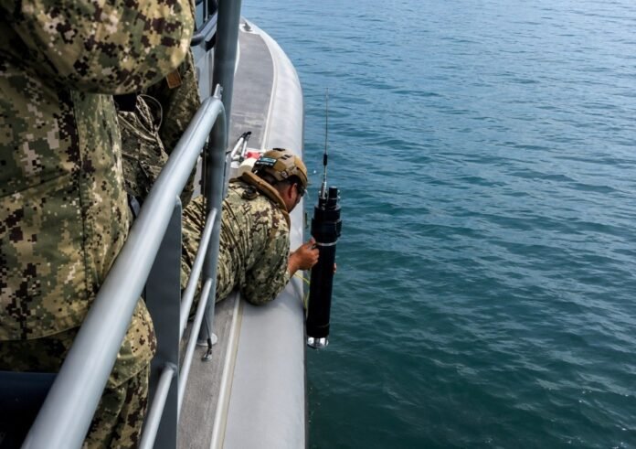 U.S. Navy sailor employing the Hammer of the Gods emitter, a maritime variant of an electronic warfare system.